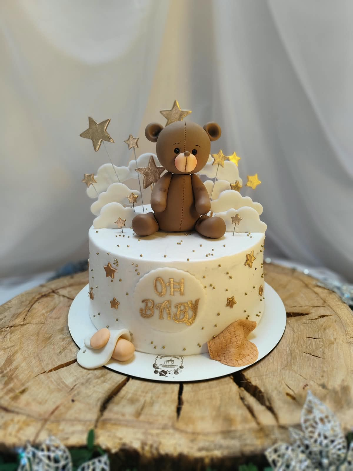 Pastel de baby shower con osito, nubes y estrellas doradas