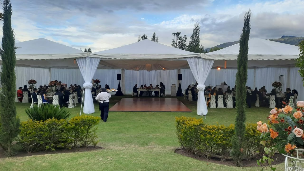Carpa blanca con invitados y pista de baile en un evento